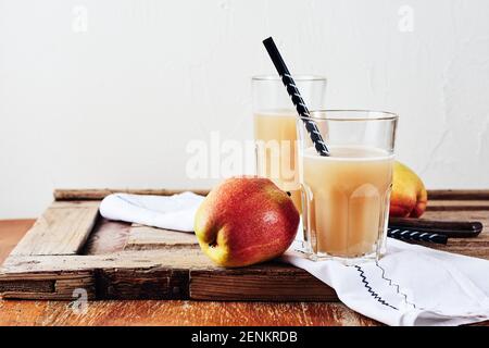 Apfel-Birnen-Saft und frische Birnen auf einem Holztisch. Stockfoto