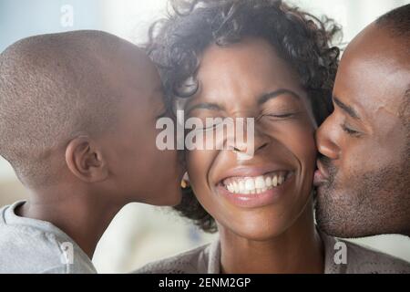 Junge und Mann, die Frau auf Wangen küssen Stockfoto