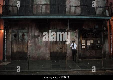 Ein Musiker vor der berühmten Preservation Hall im French Quarter von New Orleans, der das reiche Jazz-Erbe und den zeitlosen Charme der Stadt verkörpert. Stockfoto