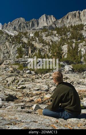 Junger Wanderer, der Middle Palisade aus der Nähe von Brainard Lake, der Palisades Region, John Muir Wilderness, Eastern Sierra Nevada, California USA, betrachtet Stockfoto