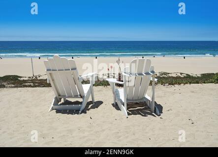 Zwei weiße Adirondack-Stühle am Strand Stockfoto