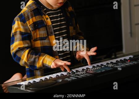 Nahaufnahme der Kinderhände, die mit dem elektrischen Klavier plippten Stockfoto