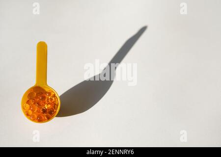 Gelbe Gel transparente Gel-Kapseln von Vitamin d oder Omega 3 in Löffel. Stockfoto