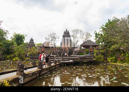 Menschen, die am Lotusgarten am Tempel von Särwati vorbeigehen (Palast Von Ubud) Stockfoto