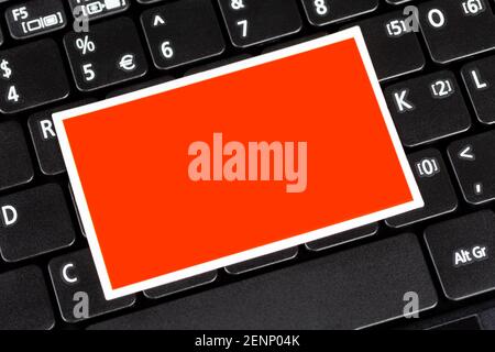 Leeres rotes Etikett, leerer rechteckiger Aufkleber, Papierkarte, Notiz auf einer Laptop-Computer-Tastatur Nahaufnahme. Copy Space, Textbox Objekt, Information Techno Stockfoto