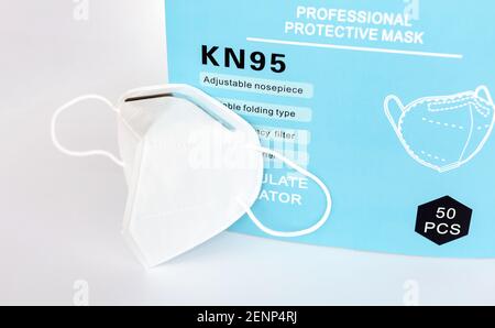 Single KN95 professionelle weiße schützende medizinische Gesichtsmaske mit Filter neben einer Box, Nahaufnahme, niemand. Einfacher neuer KN 95 antiviraler Maskenbehälter, Bul Stockfoto