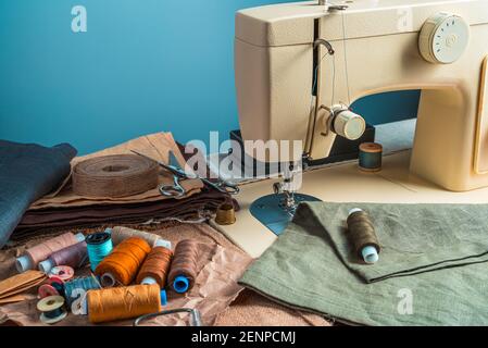 Der Arbeitsplatz des Schneidermeisters auf blauem Hintergrund. Seitenansicht mit Kopierbereich. Stockfoto