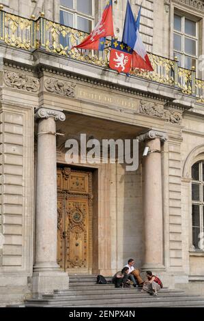 Eine Gruppe sitzt auf den Stufen des Hotel de Stadt Stockfoto