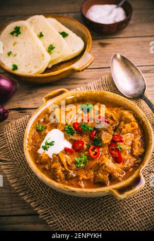 Ungarische Szegedingulasch mit eingelegtem Weißkohl (Sauerkraut), Zwiebeln und Brotknödeln in der Pfanne Stockfoto