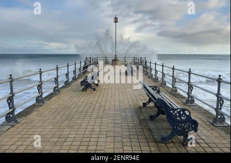 Eine Welle, die gegen Ende des Piers Banjo in Swanage, Dorset, UK. Stockfoto