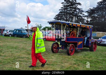 BITZA eine Replik Old Time Steam Fair Motor gebaut aus Ersatzteile von J.Borthwick, die bei der Southwick Steam geführt werden Fair von einem Mann mit roter Flagge Stockfoto