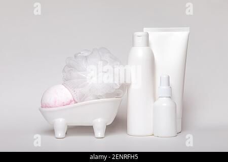 Weißes Konzept. Körpercreme, Shampoo, Medizin, Make-up, Kosmetikflasche, Keramikbad, Seifenschale, aromatische Bombe, Duschschaum und Waschlappen. Hygiene und Stockfoto