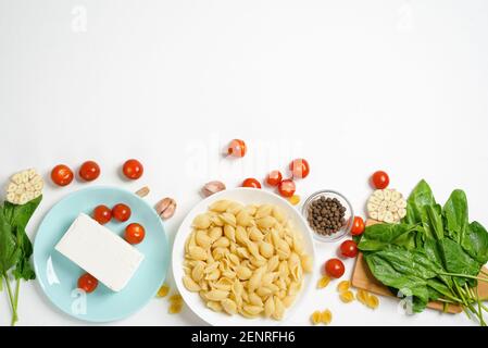 Zutaten für im Ofen gebackenen Feta-Käse mit Tomaten und Nudeln, Pfeffer Knoblauch auf einem hellen Hintergrund Draufsicht. Stockfoto