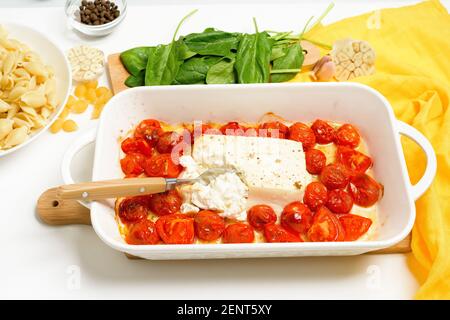 Schritt-für-Schritt Zubereitung und Zutaten für im Ofen gebackenen Feta-Käse mit Tomaten und Pasta, Pfeffer Knoblauch auf hellem Hintergrund Draufsicht, Trend Recip Stockfoto