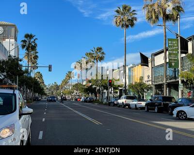 Rodeo Drive, CA USA - 20. Januar 2021: Blick auf die Straße des Rodeo Drive mit Palmen, Autos und Einkaufsgebäuden Stockfoto