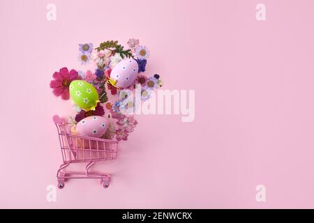 Frohe Ostern große Jagd oder Verkauf Banner mit bunten Eiern im Warenkorb auf rosa Hintergrund. Stockfoto