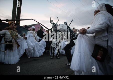 Die Schädel- und Knochenbande mit den Mystic Seven Sisters in den Straßen des New Orleans Mardi Gras Morgen bei Sonnenaufgang. Stockfoto