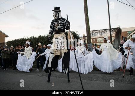 Die Schädel- und Knochenbande mit den Mystic Seven Sisters in den Straßen des New Orleans Mardi Gras Morgen bei Sonnenaufgang. Stockfoto