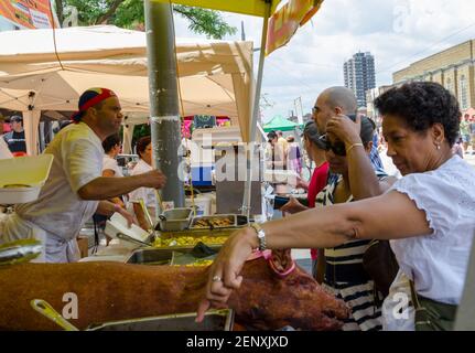 Salsa auf dem St. Saint Clair Festival Szenen: Die Leute an einem Outdoor-Food-Stand schauen über die Serviertabletts, um zu entscheiden, was sie essen wollen. Die Dame im Stockfoto