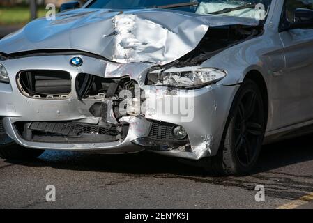 Auf der Motorhaube dieses Beamer sieht man rote Farbe, nachdem er auf einer belebten Stadtstraße in die Rückseite eines Doppeldeckerbusses eingeschlagen wurde. Stockfoto