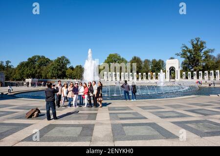 Gruppe von asiatischen Touristen posiert für ein Foto an der World war II Memorial Wasserbrunnen, National Mall, Washington D.C., USA. Stockfoto