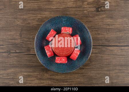 Schüssel mit Sushi-Rollen und rotem Kaviar auf Holztisch Stockfoto