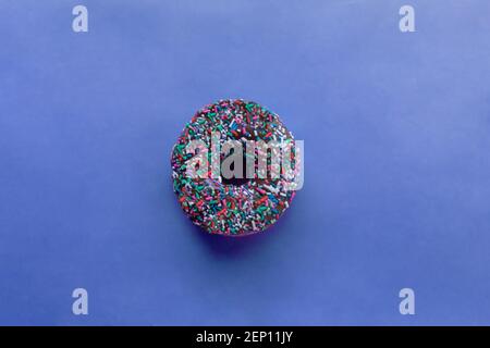 Donut mit Streuseln isoliert auf blauem Hintergrund Stockfoto