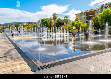 Touristen und Franzosen genießen einen sonnigen Tag an der Promenade du Paillon Water im Stadtzentrum von Nizza, Frankreich, an der französischen Riviera. Stockfoto