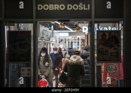 BELGRAD, SERBIEN - 11. JANUAR 2021: Menschenmenge von Kunden, die in Belgrad, während der Kasse des Supermarktes mit Atemmaske zum Gesicht hetzen Stockfoto