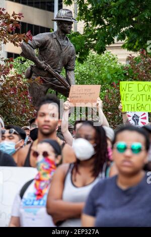 Demonstranten halten während der Demonstration Schilder vor der Ohio Statehouse Statue von Soldaten.Demonstranten versammelten sich vor dem Ohio Statehouse und marschierten nach Norden auf der High Street in einer Demonstration gegen Polizeibrutalität, Rassismus und die Tötung von George Floyd durch Minneapolis Polizeioffizier Derek Chauvin am 25. Mai, 2020. Stockfoto