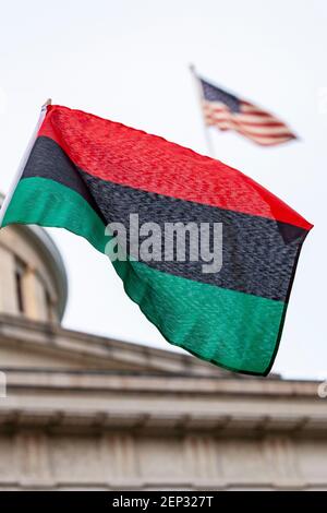 Während der Demonstration winkt die panafrikanische Flagge oder die afro-amerikanische Flagge vor der amerikanischen Flagge.Demonstranten versammelten sich vor dem Ohio State House und marschierten in einer Demonstration gegen Polizeibrutalität nach Norden auf der High Street. Rassismus und die Tötung von George Floyd durch Minneapolis Polizeioffizier Derek Chauvin am 25. Mai 2020. Stockfoto