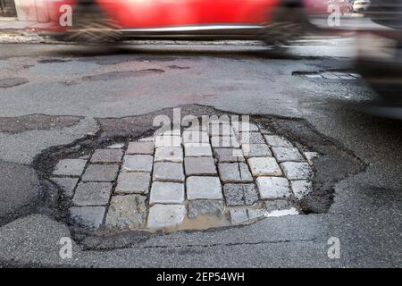 Leipzig, Deutschland. Februar 2021, 19th. Autos fahren über eine Straße mit Schlaglöchern. Wie in jedem Winter sind die Straßen besonders durch den Wechsel von Frost und Tauwetter betroffen. Quelle: Jan Woitas/dpa-Zentralbild/dpa/Alamy Live News Stockfoto