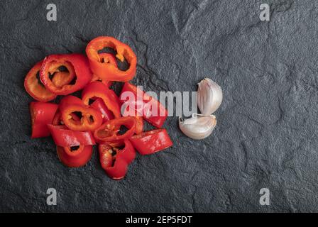 Nahaufnahme Foto von Paprika Scheiben mit Knoblauch auf Schwarzer Hintergrund Stockfoto