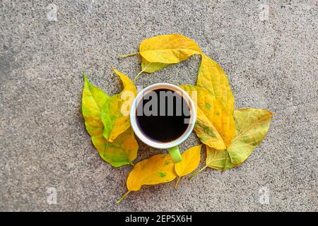 Draufsicht Tasse Kaffee mit Herbstblättern auf Zement Boden Stockfoto