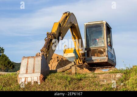 Großer Baubagger von gelber Farbe auf der Baustelle Mit blauem Himmel Hintergrund Stockfoto