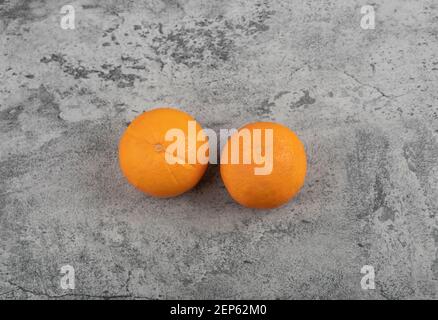 Zwei frische Orangenfrüchte isoliert auf Steintisch Stockfoto