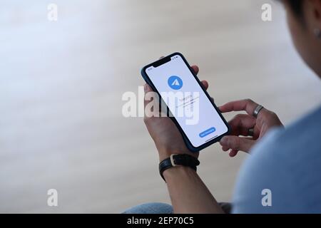 CHIANG MAI, THAILAND - FEB 08, 2021 : man Holding i Phone 11Pro max Eröffnung Telegram App, Telegram ist ein Online-Social-Media-Netzwerk. Social-Media-App. Stockfoto