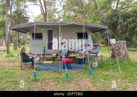 Graue Nomaden, Vicki und Gary (Middo) Middleton (rechts) unterhalten sich mit einem Besucher vor ihrer Karawane in Bendelong, New South Wales, Australien Stockfoto