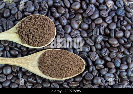 Draufsicht auf Kaffeebohnen und Kaffeepulver auf altem Holzhintergrund. Kaffeebohnen auf Sackleinen über Holztisch mit Kopierplatz für jedes Design. Stockfoto