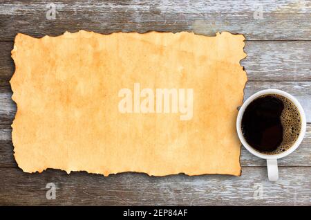Blick von oben mit altem Papier und einer Tasse Kaffee auf dem Schreibtisch oder Holztisch im Hintergrund am Arbeitsplatz. Stockfoto