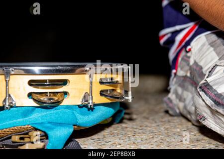 Ein Gipsmensch, der sich in einer Nacht ausruht, mit einer Handtrommel auf einer Betonbank, Tamburine auf der Tasche, Jipsy-Mann Stockfoto