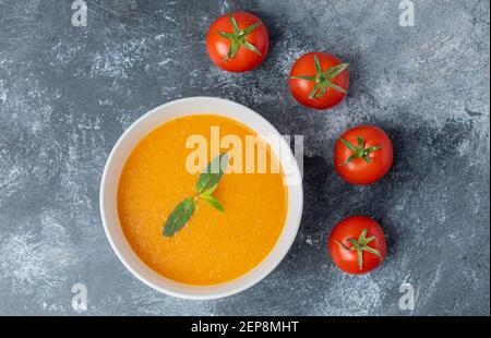 Leckere, farbige Tomatencremesuppe mit frischen Tomaten Stockfoto