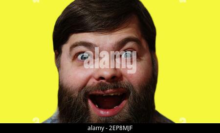 Hochformat. Ein lächelnder bärtiger Mann auf gelbem Hintergrund. Stockfoto