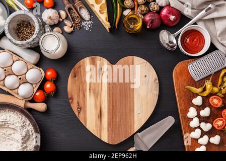 Frau bereitet ein festliches Abendessen für zwei zu Ehren von Valentinstag klassische italienische Pizza Margherita in Form von Ein Herz und Mozzarella im sh Stockfoto