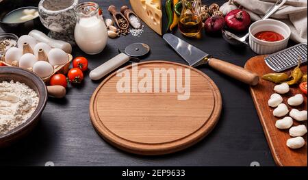 Klassische Pizza margherita mit herzförmigem Mazarella-Käse. Vorbereitung eines phasenweisen Galadinner für zwei zu Hause zu Ehren des Valentinstag. Stockfoto