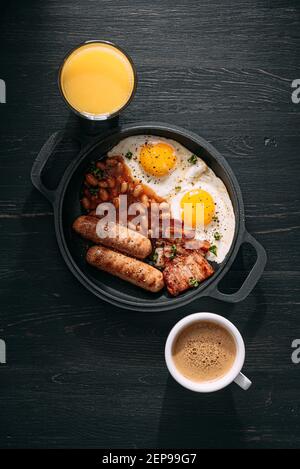 Klassisches englisches Frühstück mit Spiegeleiern, Würstchen und Bohnen Speck Stockfoto