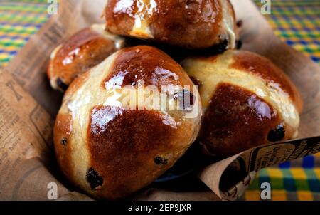 Fünf heiße Kreuzbrötchen in einem Korb zu Ostern. Stockfoto
