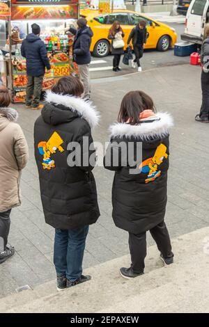 asiatisches Paar in identischen Simpsons Mänteln an Essensständen draußen Von New York das Metropolitan Museum of Art in NYC Stockfoto