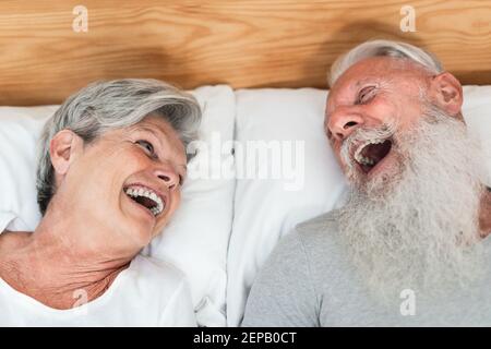 Glücklich verheiratet Senior Pärchen mit Spaß liegen im Bett - Hauptfokus auf Frau Gesicht Stockfoto