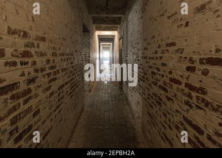 Licht Am Ende Des Tunnels. Schmaler gemauerter Korridor mit natürlichem Licht, das durch den Ausgang strömt. Stockfoto